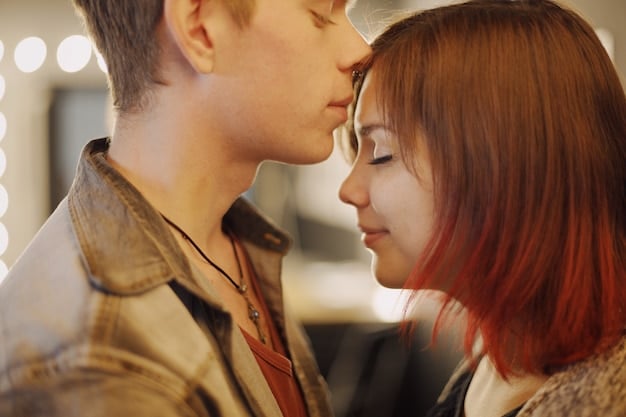 A slightly blurred close-up of a couple in a Korean drama, mid-passionate kiss, focus on their intertwined hands and the slight flush on their faces, conveying intense emotion.