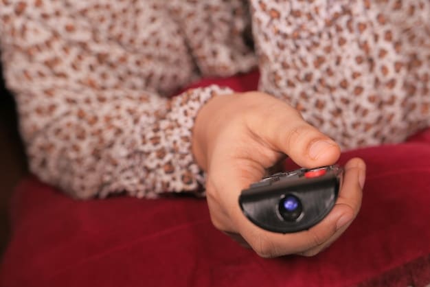 Close-up of a person's hands holding a remote control, pausing a Japanese drama on a television screen. The screen displays a scene with Japanese characters speaking, but the subtitles are turned off.