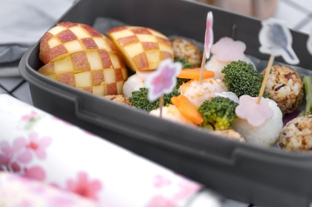 A perfectly arranged bento box showcasing various compartments filled with colorful and delicious-looking Japanese dishes. The bento box includes rice, grilled salmon, tamagoyaki (rolled omelet), edamame, and a variety of pickled vegetables. The arrangement is neat and visually appealing, highlighting the care and attention to detail that goes into preparing a traditional bento box.