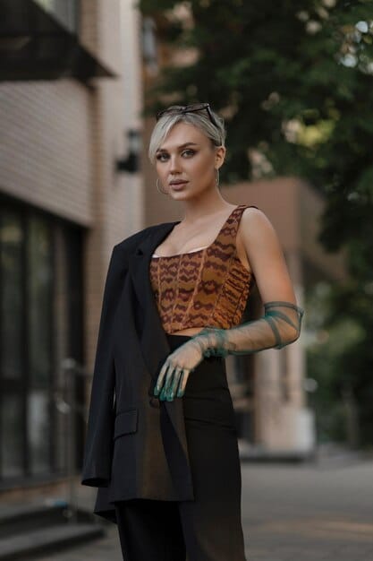A young American woman in 2025, with a stylish, layered outfit inspired by minimalist J-drama fashion. She is wearing an oversized blazer over a simple turtleneck, with wide-leg trousers, standing in a coffee shop with a serene, natural-light atmosphere.