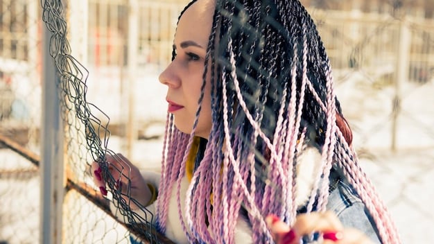 A close-up of a Japanese woman with an intricate, avant-garde hairstyle featuring braided sections woven with colorful ribbons in a futuristic, artistic manner. The lighting is dramatic, highlighting the texture and details of the hair.