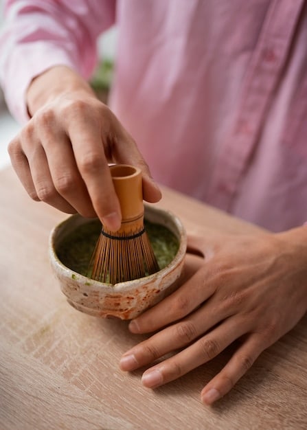 Close-up shot of a Japanese tea ceremony, focusing on the delicate movements of preparing and serving tea. The image highlights the cultural significance of this ritual.