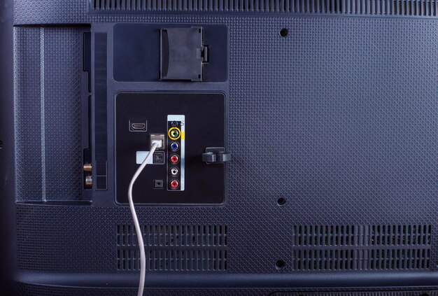 A close-up photo of the back of a modern television, clearly showing the HDMI ports, USB ports, and power input. Cables are neatly connected to some of the ports, illustrating how to properly connect a streaming device.