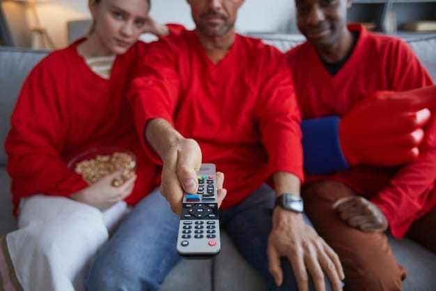 A close-up of a diverse group of people's hands collectively holding different streaming devices (Roku remote, Fire TV remote, Apple TV remote, Chromecast remote), symbolizing choice and shared entertainment.